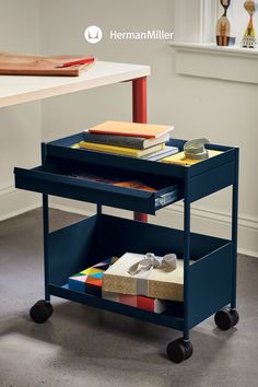 a blue rolling cart with books on it