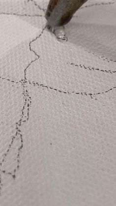 a close up of a piece of cloth with stitching on it and a needle in the middle