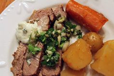 a white plate topped with meat, potatoes and carrots