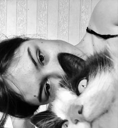 a black and white photo of a woman holding a cat