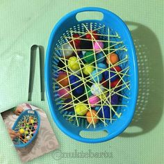 a blue basket filled with lots of different colored balls next to a knife and fork