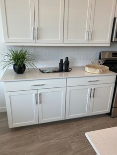 a kitchen with white cabinets and black appliances