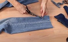 someone cutting up some jeans with scissors on the floor next to them and several pairs of shoes