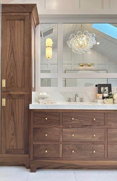 a bathroom with a large mirror and wooden cabinets