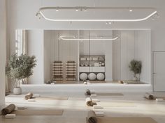 an empty yoga studio with white walls and wooden flooring, surrounded by exercise mats