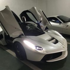 two white sports cars parked next to each other