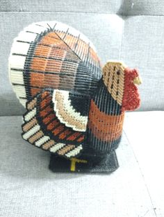 a decorative chicken sitting on top of a couch