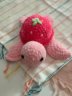 a pink stuffed animal laying on top of a blanket