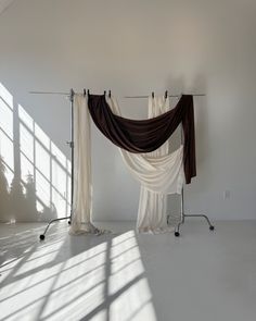 an empty room with two drapes hanging from the ceiling