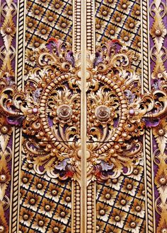 an intricately designed door with gold and purple trimmings on the side of it