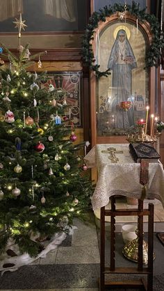 a small christmas tree in front of a church alter with candles and decorations on it