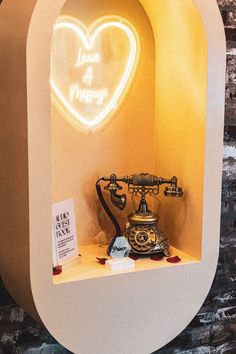 an old fashioned phone is on display in the shape of a heart with neon lights