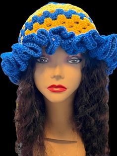 a mannequin head wearing a blue and yellow hat with flowers on it's brim