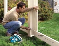 a man is working on the side of a house with siding tape around his legs