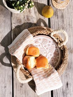 some rolls are sitting on a plate next to a potted plant and lemons