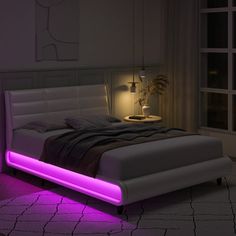 a bed with purple lights on it in a dark room next to a large window