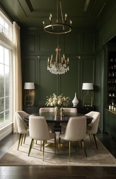 an elegant dining room with green walls and chandelier