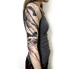 a woman with a black and white tattoo on her arm