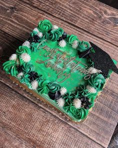 a cake with green frosting and black decorations