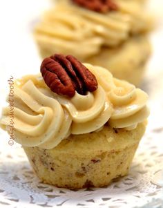 three cupcakes with frosting and pecans on top