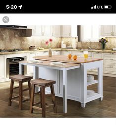 a kitchen island with two stools next to it and an app on the phone