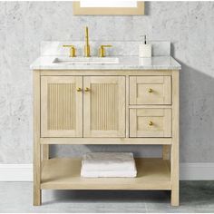 a bathroom vanity with white marble top and gold faucet