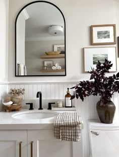 a bathroom with a toilet, sink and mirror in it's centerpieces