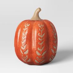 an orange carved pumpkin with leaves on it