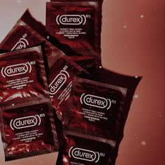 four packets of durex are sitting on a table next to each other in front of a red background