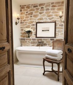 a white bath tub sitting next to a wooden chair