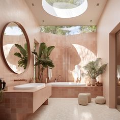 a large bathroom with pink tiles and round mirrors