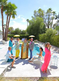 a group of people standing next to a swimming pool