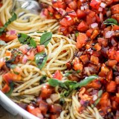 a bowl filled with pasta and vegetables on top of a table