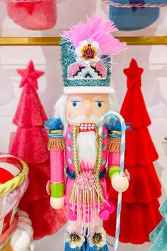 a nutcracker is standing in front of some christmas trees and other holiday decorations