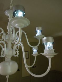 a white chandelier hanging from the ceiling in a room with several lights on it