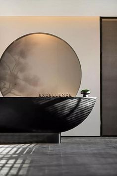 a black and white bath tub sitting next to a round mirror