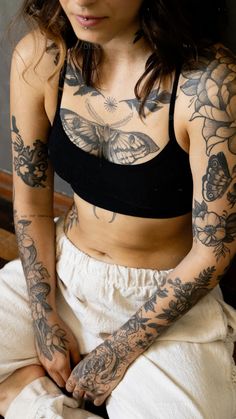 a woman with tattoos on her arm and chest