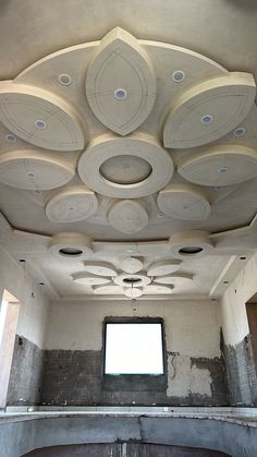 an empty room with several circular ceiling lights and windows in the center, all made out of concrete