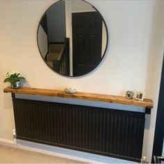 a black radiator with a round mirror above it