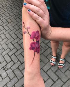 a woman's arm with purple flowers on it