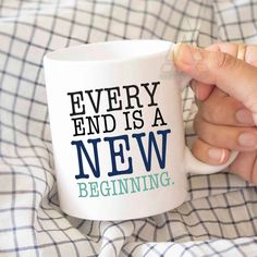 a person holding a coffee mug with the words, every end is a new beginning