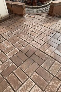 a brick patio with two planters on each side and a fire hydrant in the background