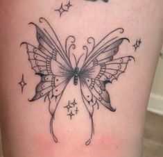 a butterfly tattoo is shown on the side of a woman's thigh, with stars around it