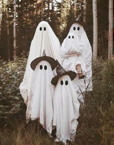 two people dressed up as ghost in the woods