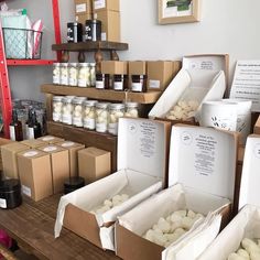 several boxes are stacked on top of each other in front of shelves with jars and containers