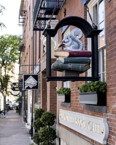 a sign that is on the side of a building with books in front of it