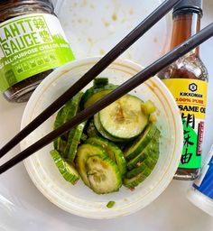 some food is sitting on a plate with chopsticks and sauce in the background