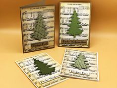 three cards with christmas trees on them and sheet music in the middle one is green