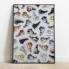 an art piece with colorful sneakers on it in front of a white wall and wooden floor