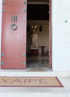 an open door with a statue in the background